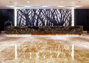 a lobby with a marble floor and a wall with trees at Amanti Hotel Seoul in Seoul