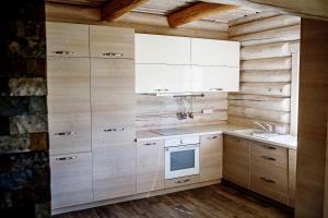 a kitchen with wooden cabinets and a sink at Vila "Laumių lankos" in Plateliai