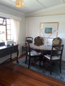 a dining room with a table and a piano at Taste Of Heaven in Bredasdorp