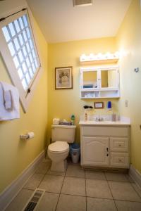 een badkamer met een toilet, een wastafel en een raam bij Friendly City Inn B&B in Harrisonburg