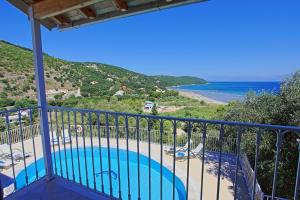 a balcony with a swimming pool and the ocean at Beach Villa Oneiro in Apraos