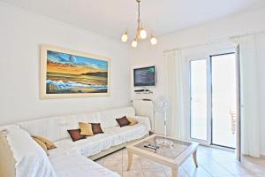 a living room with a white couch and a table at Beach Villa Oneiro in Apraos