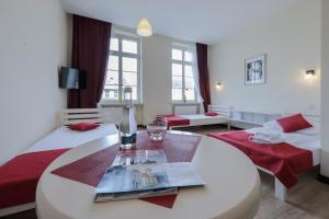 a room with two beds and a table with a wine glass at Kamienica Pod Aniołami in Wrocław