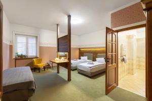 a hotel room with a bed and a bathroom at Hotel U Simla in Karlovy Vary