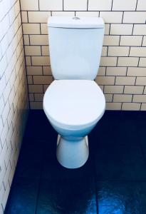 a white toilet in a bathroom with a blue floor at The Liverpool Pod Travel Hostel in Liverpool