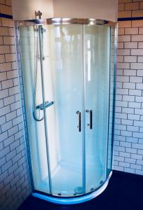 a shower with a glass door in a bathroom at The Liverpool Pod Travel Hostel in Liverpool