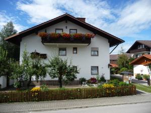 a white house with flowers on the side of it at Haus Bayrhof in Hopferau
