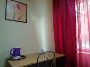 チュメニにあるHotel Four Roomsの紫色のブレンダー付きテーブルと赤いカーテン
