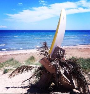 a surfboard sitting in a bag on the beach at sunmer apartment 1minute from sea, 15 min from the airport ARTEMIS CITY CENTER in Artemida