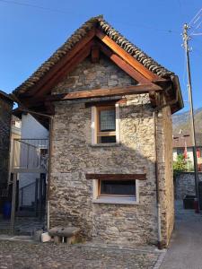 una pequeña casa de piedra con techo de madera en Rustico Cadrobi 20, en San Vittore