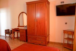 Un dormitorio con un gran armario de madera y un escritorio. en Hotel Alfonso VIII en Santa Elena