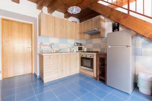 a kitchen with wooden cabinets and a white refrigerator at Apartment Janet in Luka
