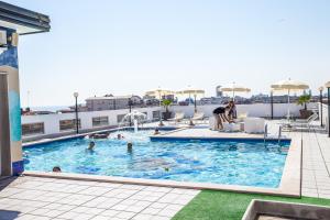 ein Pool auf dem Dach eines Gebäudes mit Menschen darin in der Unterkunft Hotel Christian in Lido di Jesolo