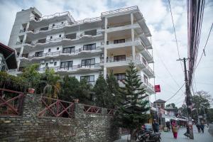 duży biały budynek na poboczu ulicy w obiekcie Hotel Himalayan Vacation w mieście Pokhara