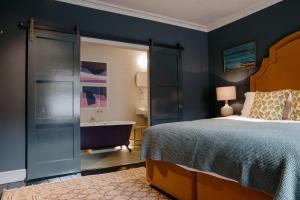a bedroom with a bed and a bathroom with a tub at The Rose in Deal