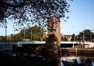 a group of boats are docked in a river at SWEETS - Gerben Wagenaarbrug in Amsterdam