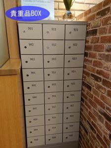 a stack of drawers in front of a brick wall at Ave Tennoji Hotel in Osaka