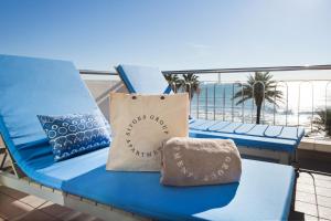 a blue chair with a bag on a balcony with the beach at Sitges Group Ocean in Sitges