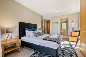 a bedroom with a large bed with a desk and a room at Enormous One Bedroom Beauty in CBD! Free Parking in Auckland