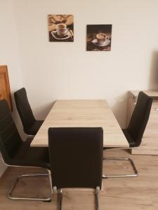 une table avec quatre chaises et une table en bois avec deux tableaux dans l'établissement Ferienwohnung Harzlust, à Goslar