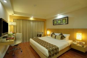 Pokój hotelowy z dużym łóżkiem i biurkiem w obiekcie Siamton Inn- A Cygnett Collection w mieście Kolkata