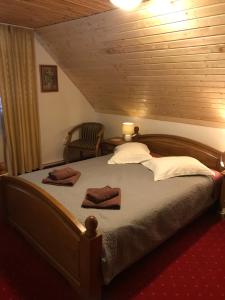 布朗的住宿－Chalet Milenium Residence Bran，一间卧室配有一张大床和两条毛巾