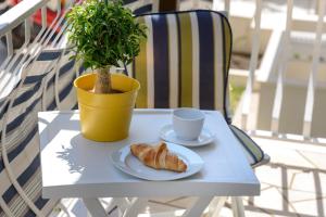 a table with a plate of croissant and a cup and a plant at Apartment Ilko in Dubrovnik