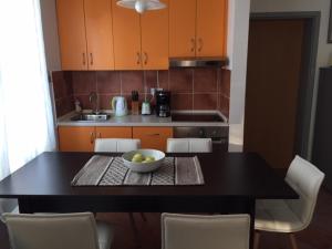 une cuisine avec une table avec un bol de fruits dessus dans l'établissement Apartments MAT, à Novalja