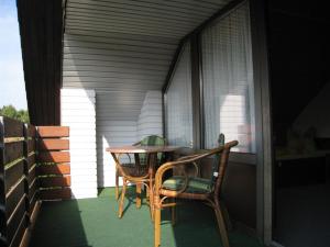 - une table et des chaises sur la terrasse couverte d'une maison dans l'établissement Meyer, à Soltau