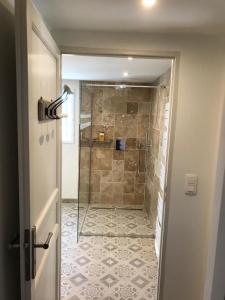 La salle de bains est pourvue d'une douche avec une porte en verre. dans l'établissement L' Esmerand, à Cotignac