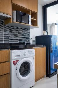 曼谷的住宿－曼谷費利斯蘇庫維特69公寓，厨房内的洗衣机配有微波炉