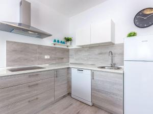 Una cocina con un refrigerador blanco y un fregadero. en Villa in Dramalj near Beach with Pool, en Dramalj