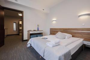 a hotel room with a large white bed and a desk at Kamienica Pod Aniołami in Wrocław +88 photos