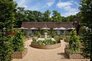 オンザンにあるLes Hauts de Loireの植物の植えられた建物の前の庭