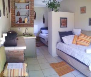 1 dormitorio con 1 cama y cocina con fregadero en Amani Guest house Clarens, en Clarens