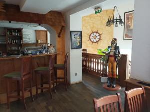 a room with a bar and a statue in a kitchen at Pirates Hotel in Hainburg an der Donau