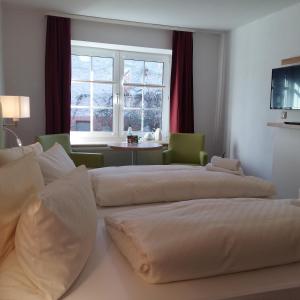 two beds in a hotel room with a window at Pension Redefin in Redefin