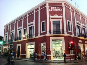 a red building on the corner of a street at Hotel Reforma in Mérida