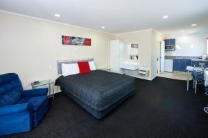 a hotel room with a bed, couch and a television at Livingston Motel in Whakatane