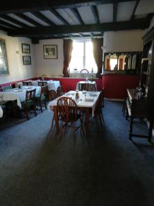 una sala da pranzo con tavoli e sedie in un ristorante di The Royal Oak a Kington