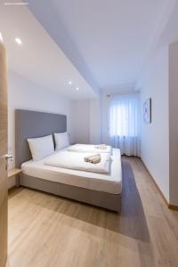 a bedroom with a large white bed in a room at City Charme Apartments in Bolzano