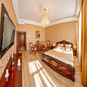 a bedroom with a large bed and a dining room at Hotel Golden Palace in Saint Petersburg