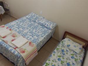 una habitación con 2 camas y una mesa con toallas en Meliza's Garden, en Foz do Iguaçu