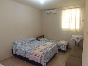 a small bedroom with two beds and a window at Meliza's Garden in Foz do Iguaçu