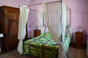 a bedroom with a bed with a canopy at Casale Poggio Colpiccione in Passignano sul Trasimeno