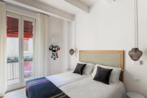Schlafzimmer mit einem Bett mit weißer Bettwäsche und Kissen in der Unterkunft Residence le Porte in Bologna