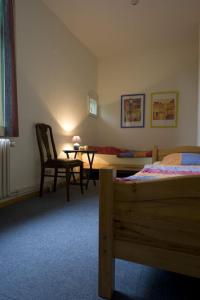 - une chambre avec un lit, une chaise et une table dans l'établissement Auf dem Berg Hude, à Hude