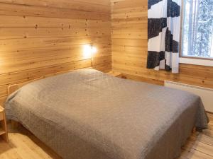 ルカにあるHoliday Home Viipusjärvi 11 by Interhomeの木製の部屋にベッド1台が備わるベッドルーム1室があります。