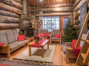 - un salon avec un arbre de Noël dans une cabane en rondins dans l'établissement Holiday Home Mäntylä a-osa by Interhome, à Nissi