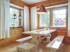 a dining room with a white table and windows at Holiday Home Laulelevi by Interhome in Levi